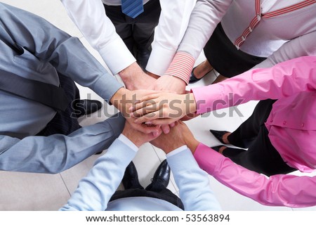Close-up of business people standing and keeping hands on top of each other