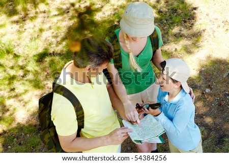 Portrait of family members looking at map in the forest at summer