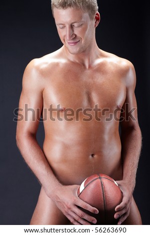 stock photo Image of naked man with soccer ball isolated over black 
