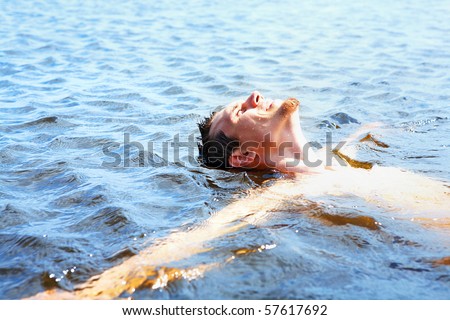 Delighted guy bathing in water and enjoying it