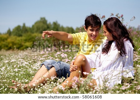 Portrait of young man showing something to woman outdoor