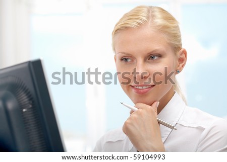 Image of young employer touching face while working in office