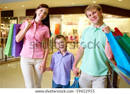 Portrait of husband and wife with their son looking at camera in trade center
