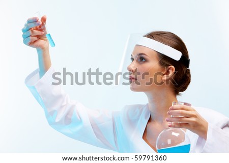 Portrait of medical specialist looking at flask on a white background