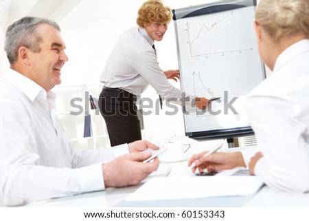 Photo of successful manager standing by whiteboard and explaining his ideas