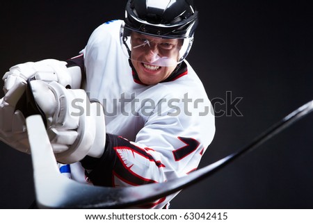 Ice-hockey player holds stick