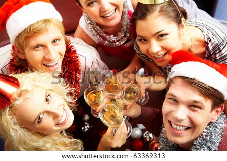 View from above of merry friends with flutes of champagne looking upwards