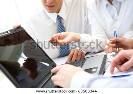 Businesswoman pointing at lcd screen while explaining something at meeting