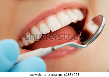 Close-up of patient s open mouth during oral checkup with mirror near by Close-up of patient s open mouth during oral checkup with mirror near by