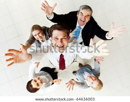 Above view of happy employer looking at camera with several partners around him