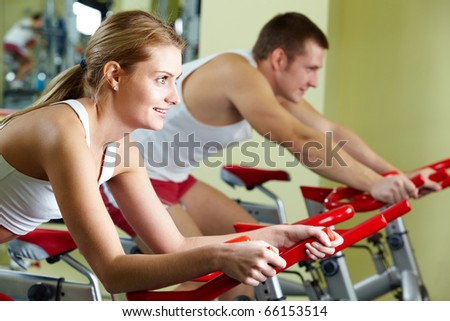 Portrait of sporty couple doing physical exercise on special equipment