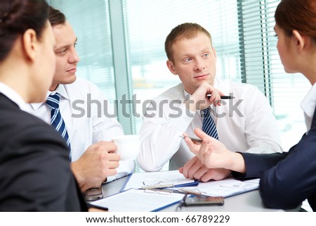 Image of confident colleagues listening to new ideas at meeting