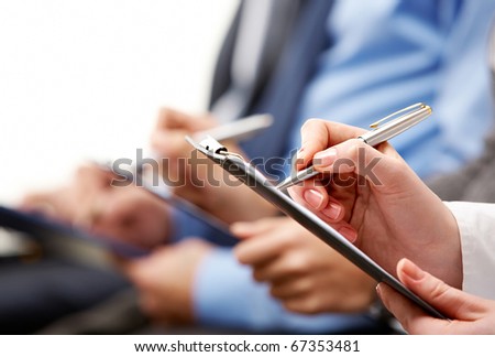 Close-up of human hand holding pen over business document Close-up of human hand holding pen over business document