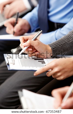 Close-up of human hands with pens over business documents