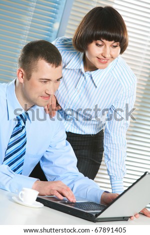 Photo of smart businessman and secretary looking at laptop screen at meeting