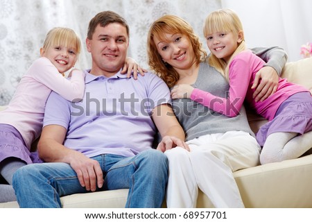 Portrait of happy family with twins sitting on the sofa