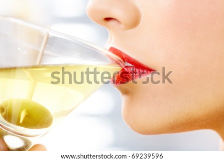 Close-up of woman drinking martini with olive