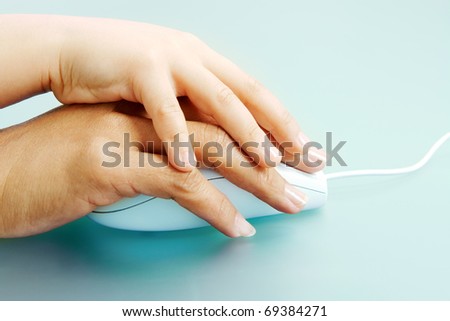 Close-up of female and childish hands on top of each other and on mouse