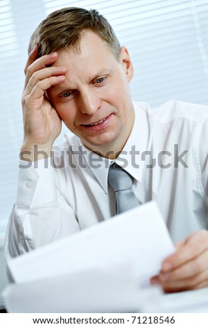 Portrait of a busy businessman looking at Portrait of a busy businessman looking at document cument