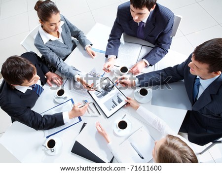 Above view of business team discussing papers at meeting Above view of business team discussing papers at meeting