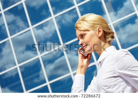 Portrait of pretty business leader talking by mobile phone with smile