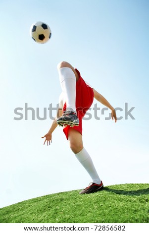 soccer player kicking ball. stock photo : Portrait of soccer player kicking ball by knee on football