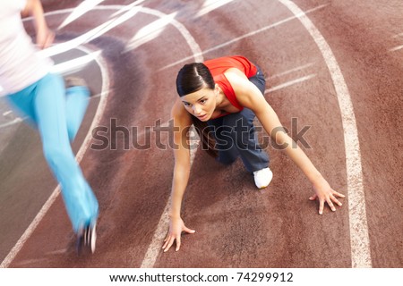 A young woman sprinter on the point of starting