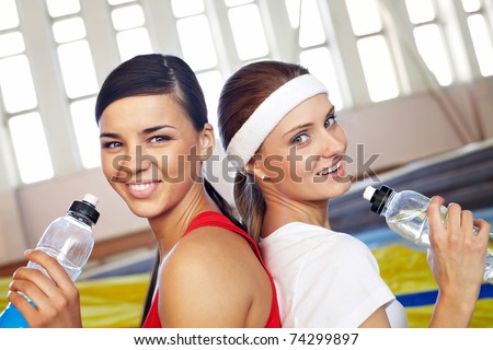 stock photo Portrait of two sporty girls taking a drink