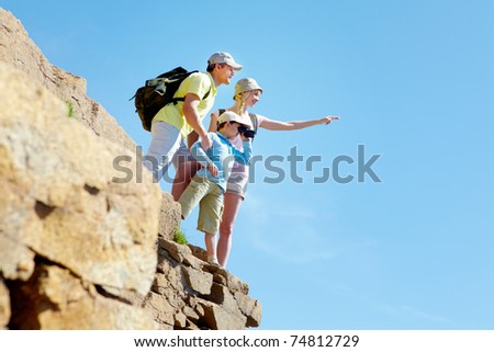 Portrait of family members looking afar outside while standing on cliff