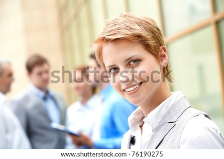 Portrait of pretty employee smiling at camera in natural environment
