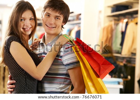 Portrait of joyful husband and wife after shopping looking at camera