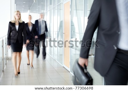 Business people walking along the office corridor
