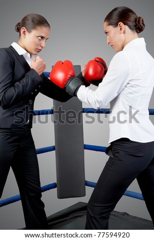 Photo of aggressive business women fighting with each other on boxing rink
