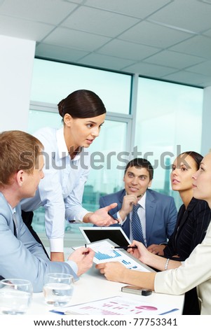 Group of business people discussing papers or sharing ideas in office