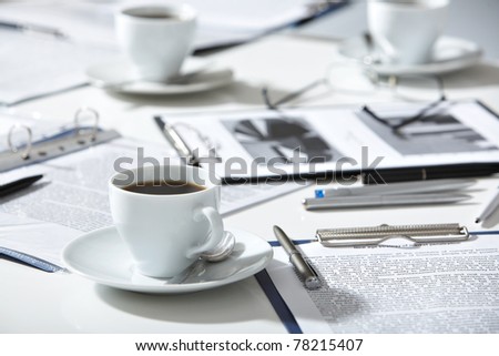 Close-up of documents, pen, cup of coffee on the table