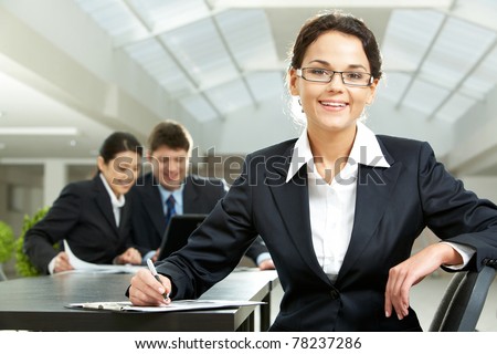 Portrait of pretty woman looking at camera in working environment
