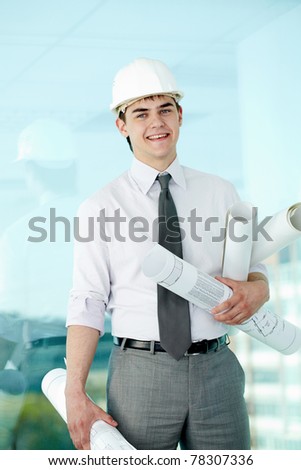 Portrait of happy architect in helmet looking at camera