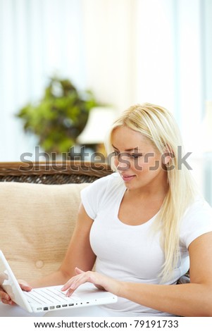 Portrait of charming blonde typing on laptop