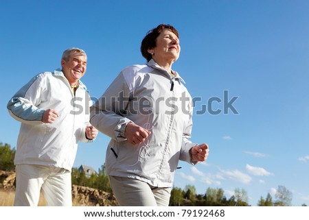 Portrait of happy mature couple running together Portrait of happy mature couple running together