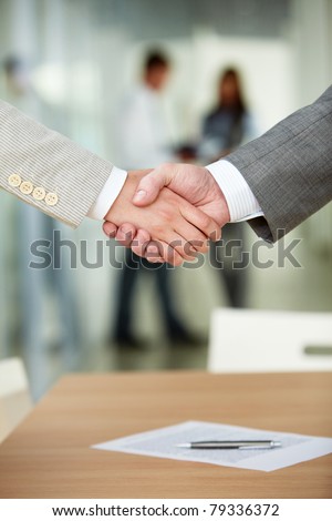 Photo of handshake of business partners after signing contract