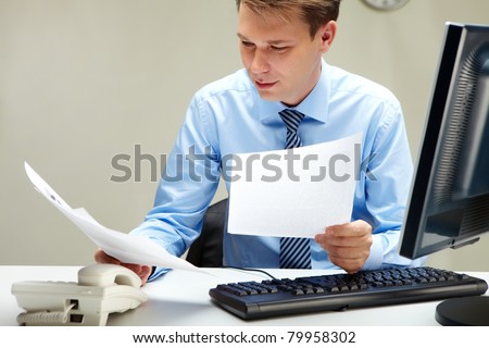 Portrait of smart businessman working with papers at workplace