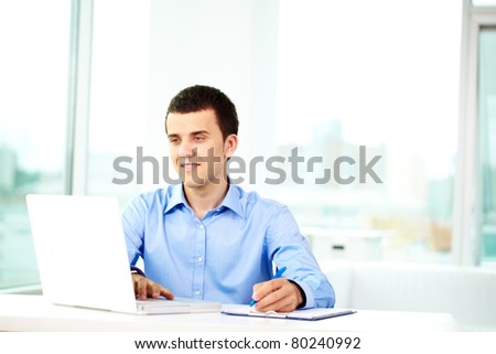Portrait of successful businessman working on computer