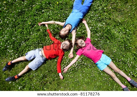 Three children having break on grass