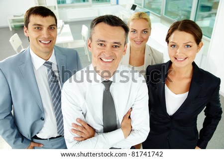 Portrait of business partners looking at camera with their leader in front