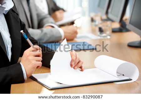 Human hand with pen holding paper during written work