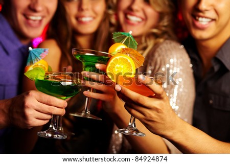 Close-up of several cocktails in young people hands