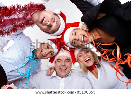 Portrait of smart colleagues in Santa caps wishing you Merry Christmas