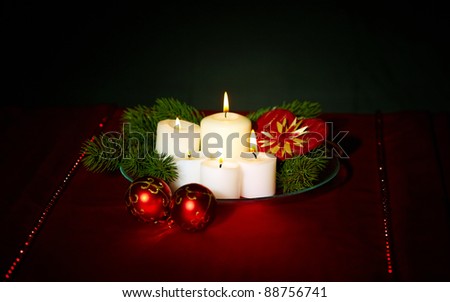 Image of holiday composition with burning candles, decorative balls and coniferous branches on it
