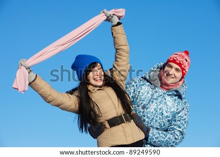 Portrait of happy couple in warm clothes looking at camera outside