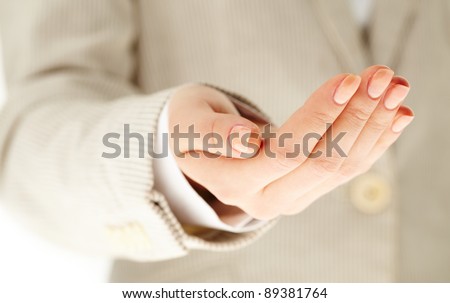 Image of human hand keeping palm up on background of female